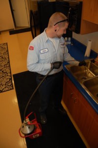 Bill Howe Drain Technician, Nate Thorson, snaking out a kitchen drain