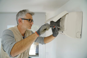 Repairman fixing air conditioner unit