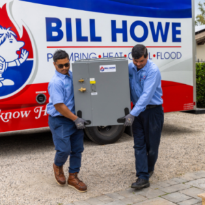 Technicians carrying a new HVAC system for installation.